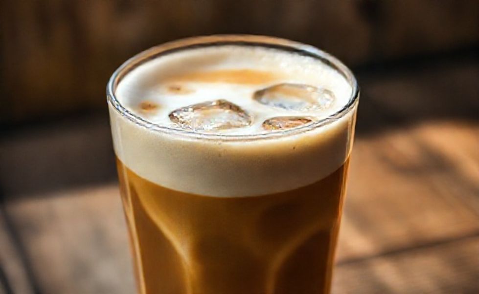 Whipped Coffee (Dalgona) servido em copo alto com espuma cremosa sobre leite gelado e gelo, textura aerada perfeita