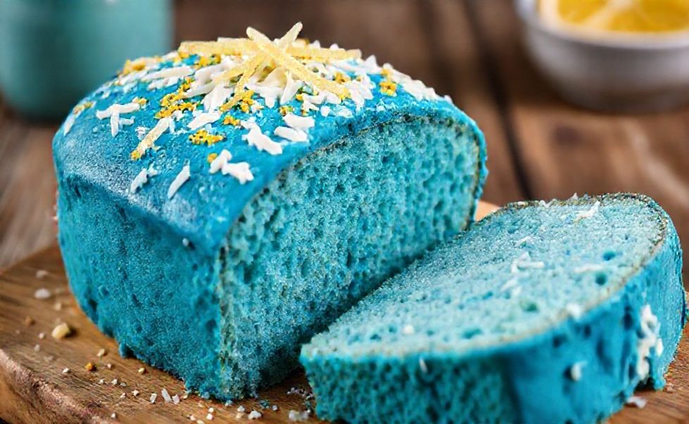 Bolo Azul vibrante cortado mostrando miolo úmido, decorado com raspas de limão em fundo rústico