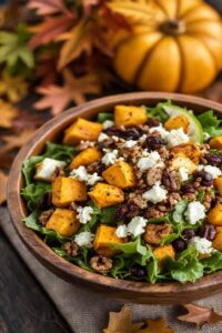 Fall harvest salad com abóbora assada, nozes tostadas, queijo feta e cranberries sobre folhas verdes, apresentação vibrante em tigela rústica