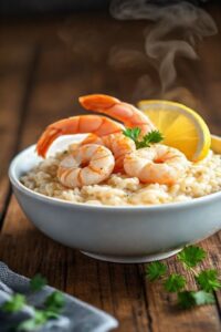 Risoto de camarão cremoso em tigela branca com camarões rosados, arroz arbóreo perfeito e decorado com salsa fresca - prato principal sofisticado