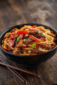 Yakisoba de carne com macarrão, legumes coloridos e molho brilhante em bowl cerâmico - ingredientes para yakisoba de carne frescos e saborosos
